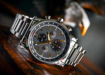 Luxury wristwatch with stainless steel bracelet displayed elegantly on a wooden background.