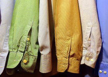 A row of vibrant, striped shirts hanging neatly, showcasing fashion variety.