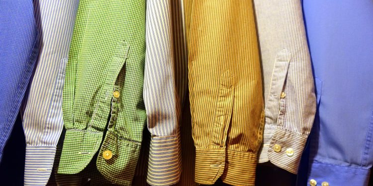 A row of vibrant, striped shirts hanging neatly, showcasing fashion variety.